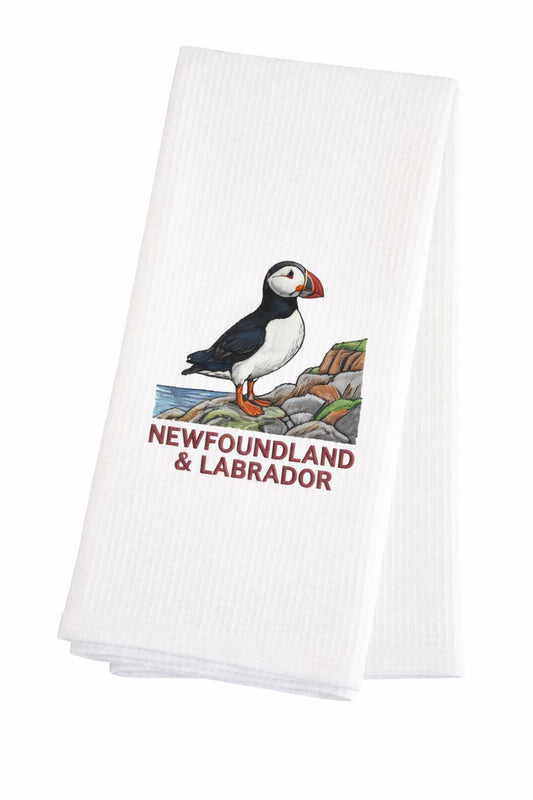 White waffle weave tea towel with a puffin on the rocks and Newfoundland & Labrador underneath